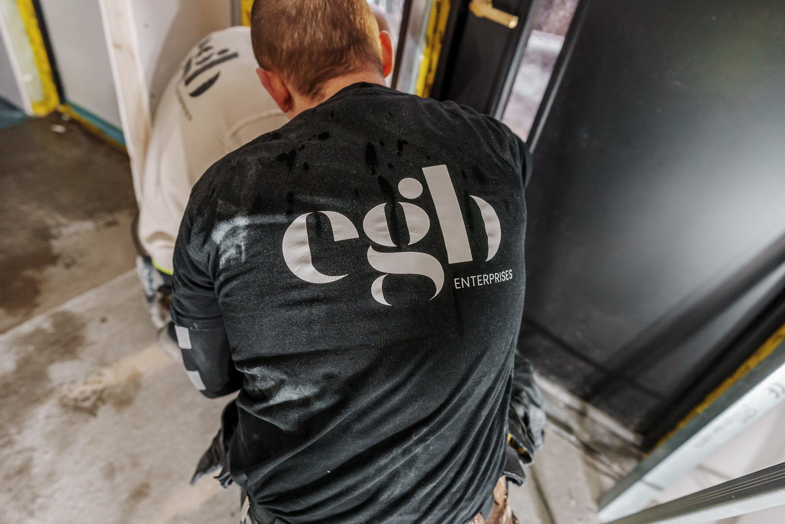 Tømrer i EGB-t-skjorte, sett bakfra