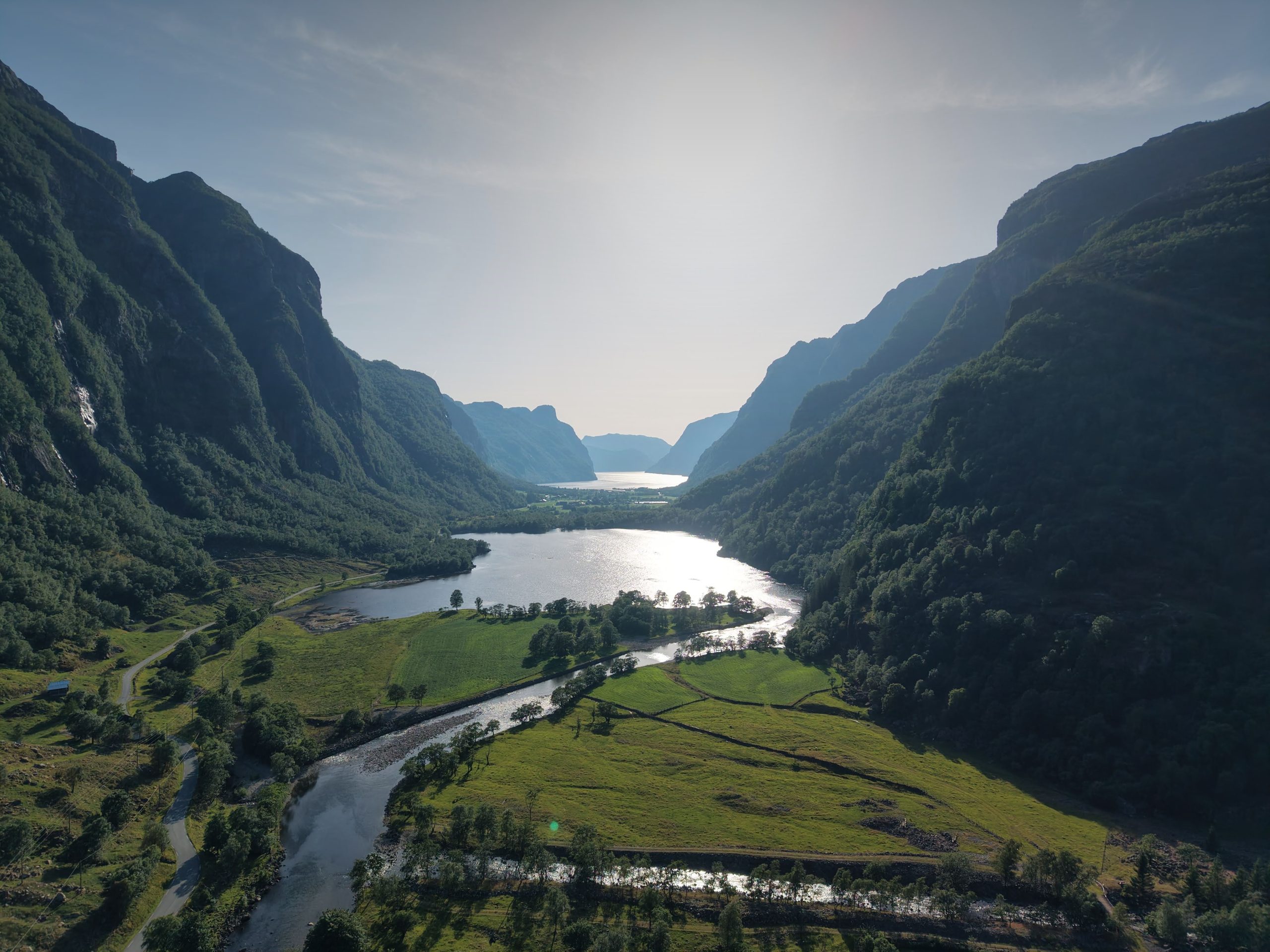 Fjorddal med elv og innsjø sett fra drone