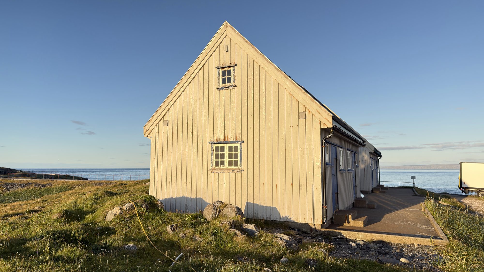 Bygning på Kjølnes fyrstasjon i Berlevåg, med havet bak